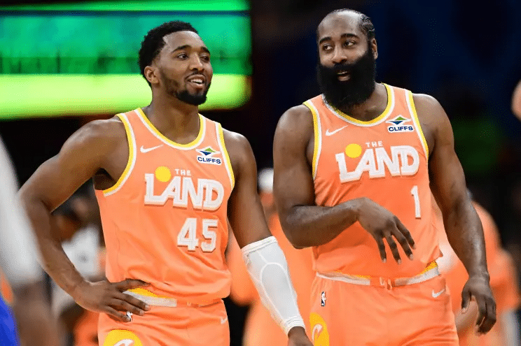 cavs mitchell - Digital Wager Wire Two basketball players in bright orange uniforms labeled 'THE LAND' stand together on the court, #45 on the left and #1 on the right, smiling.