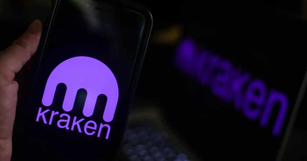 kraken photo - Digital Wager Wire Purple Kraken logo glowing on a smartphone screen in a dark setting.