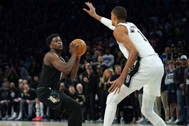 wemby blocked - Digital Wager Wire Two basketball players compete under a crowded arena: a black-clad player protects the ball while dribbling as a defender in white guards him.