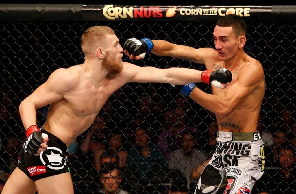 win mcgregor win 1st - Digital Wager Wire Two shirtless mixed martial artists clash inside a chain-link cage as one lands a left jab to his opponent's face.