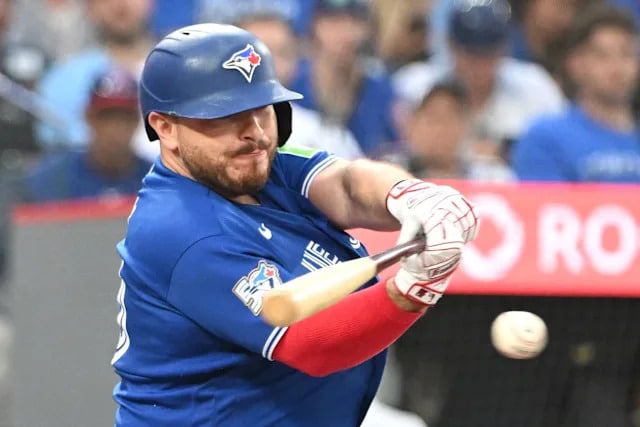 blue jay - Digital Wager Wire Toronto Blue Jays batter swings at a pitched ball during a game, bat mid-swing with crowd in background.