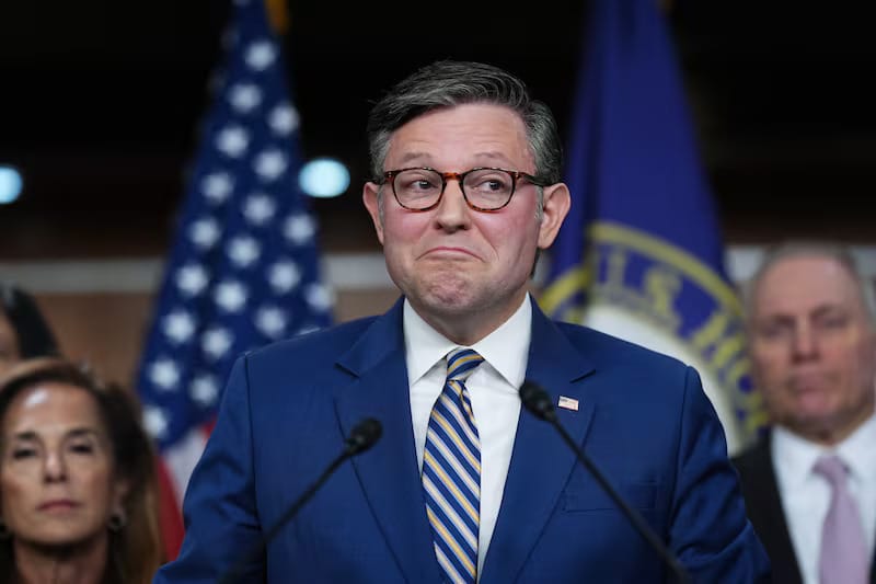 house bill passsed - Digital Wager Wire Politician in a blue suit and striped tie speaks at a podium with microphones, flanked by US and official flags.