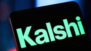 Close-up of a smartphone screen displaying large neon-green text on a dark background, the word partially visible at an angle.