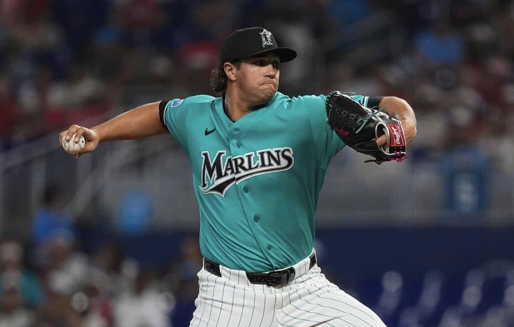 Marlins pitcher in teal uniform throwing a pitch during a game.
