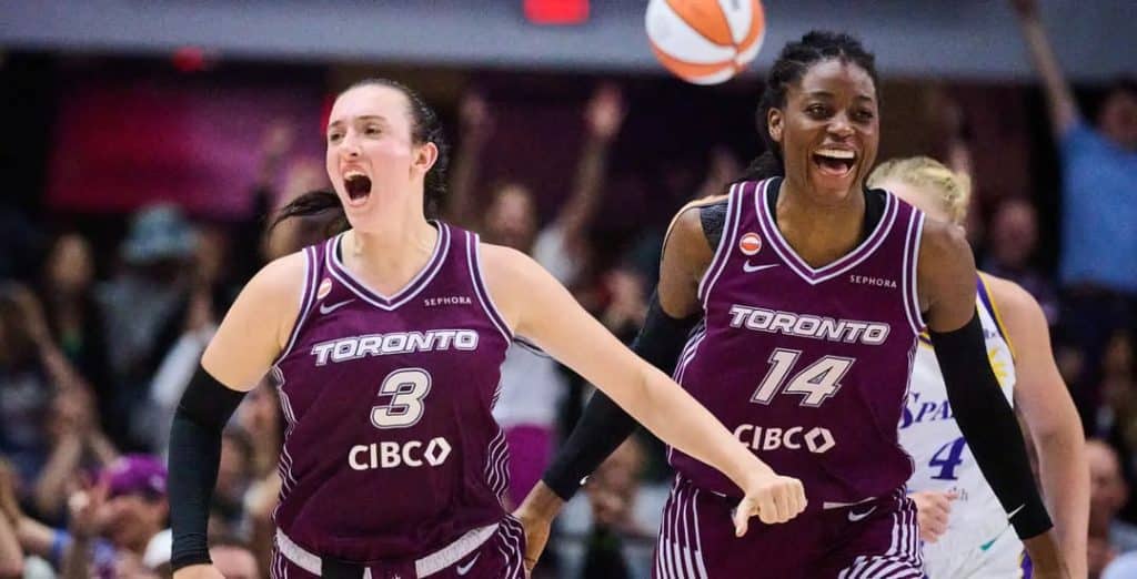 toronto tempo - Digital Wager Wire Two Toronto basketball players in maroon jerseys celebrate on a crowded court as a ball flies overhead.
